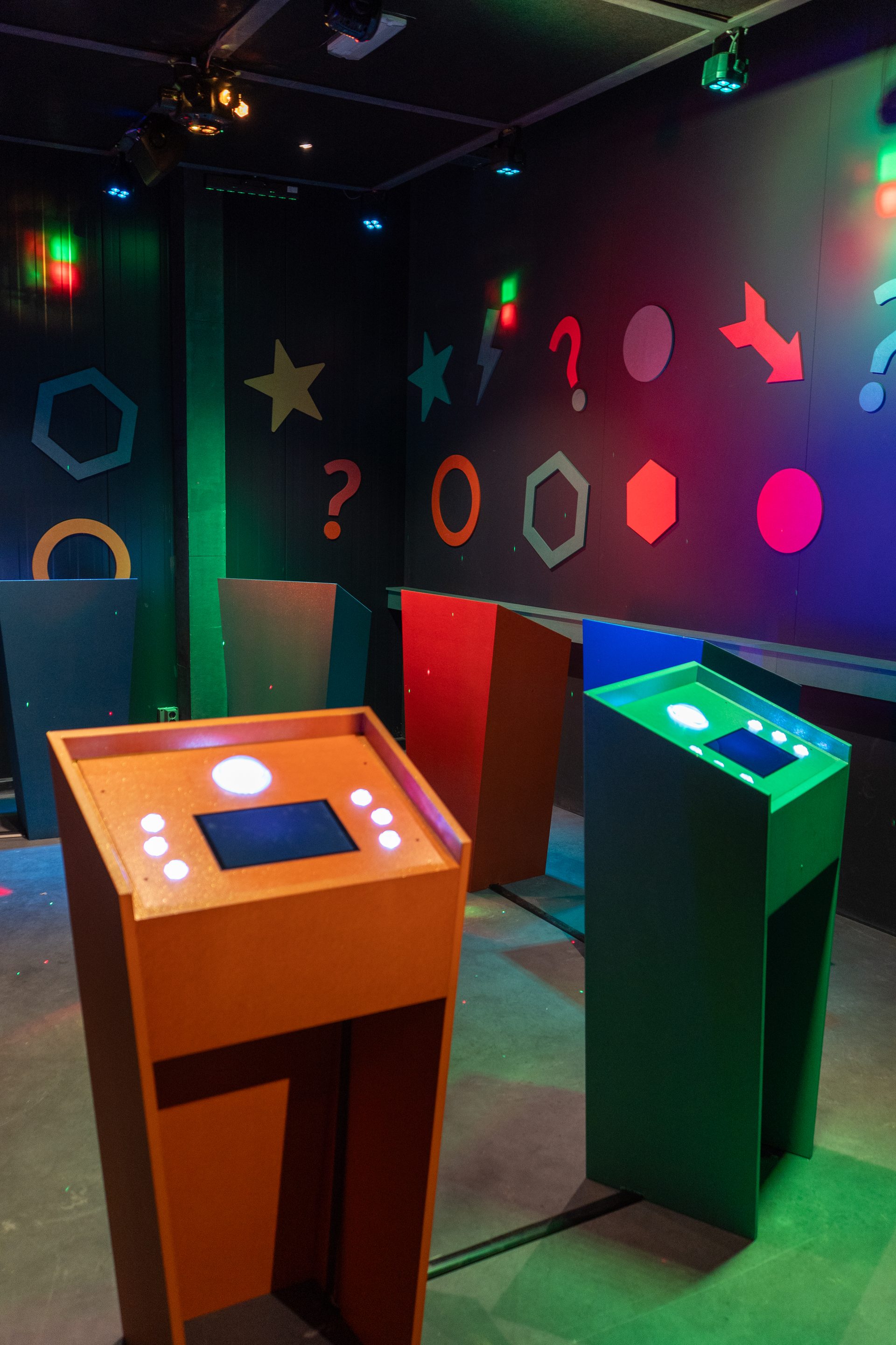 Colorful buzzer desks inside the QuizX Arena game show room