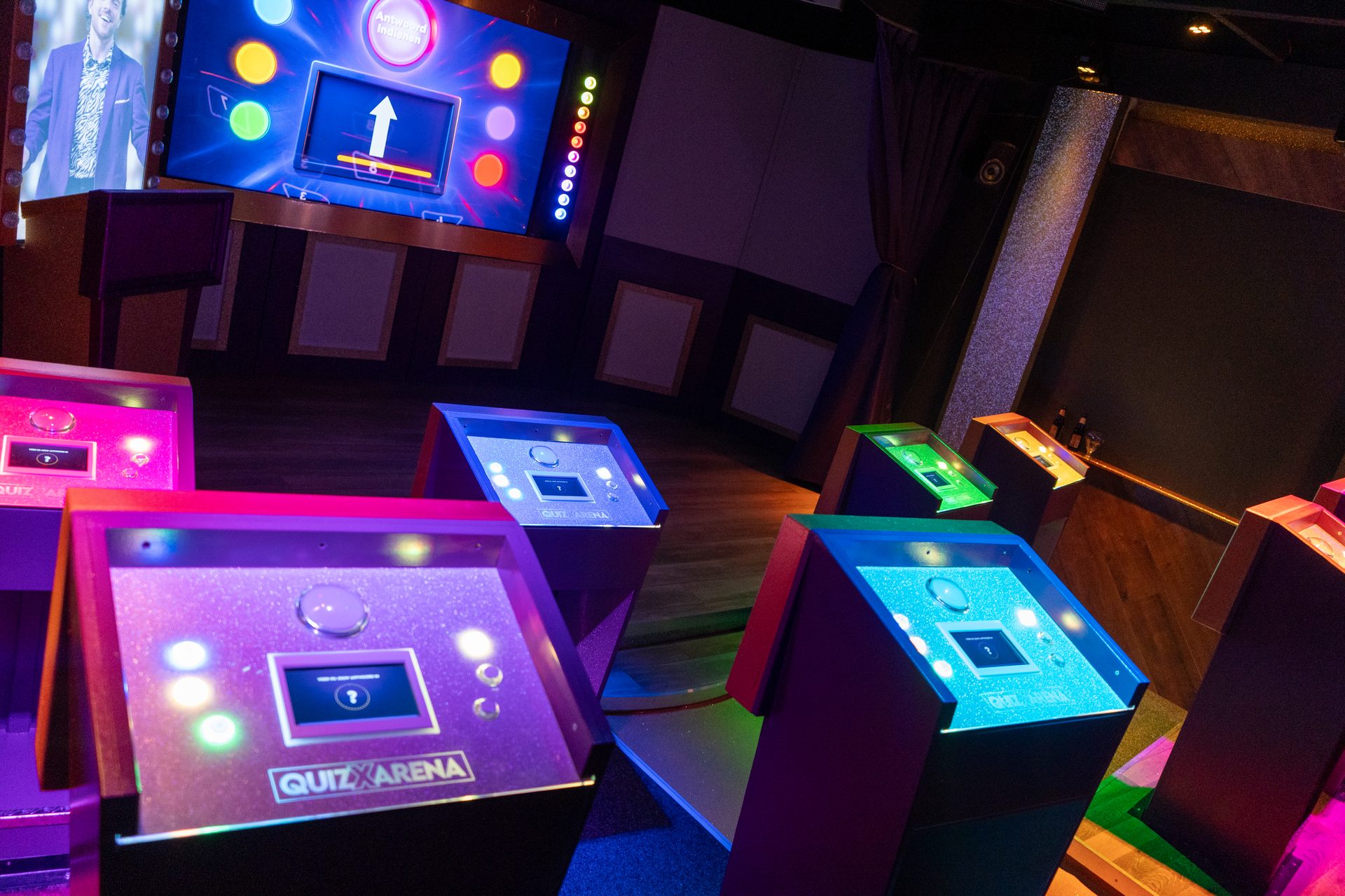 QuizX Arena desks with buzzers and illuminated quiz screen